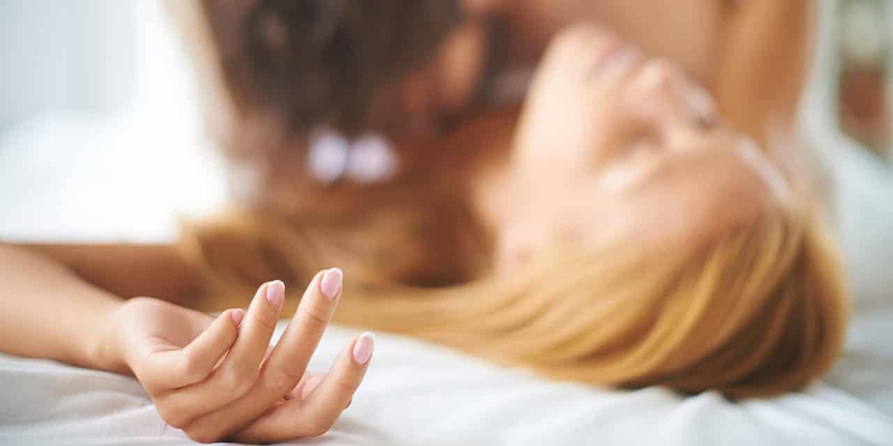 Ein Paar im Bett hat offenbar Sex.